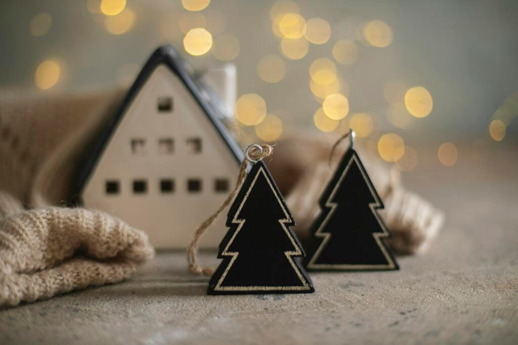 Ceramic house insulated by warm sweater and tree Decor on background