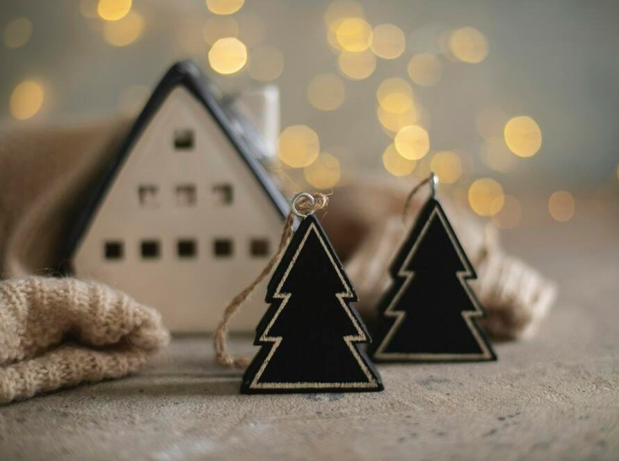 Ceramic house insulated by warm sweater and tree Decor on background