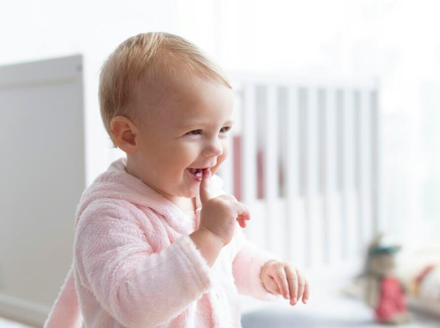 Cute baby girl smiling in her nursery