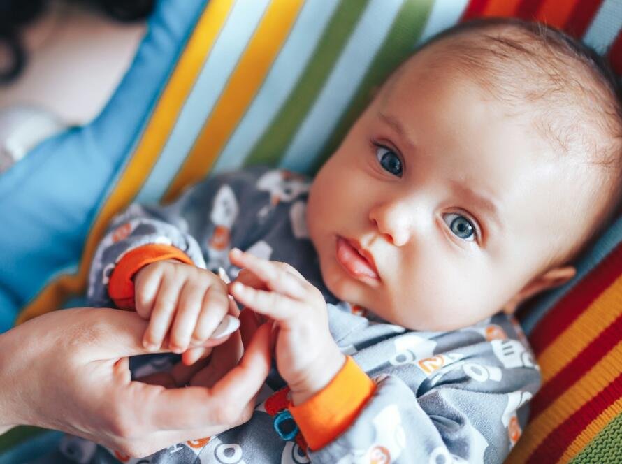 Little newborn baby holding parent's one hand, close-up macro shot