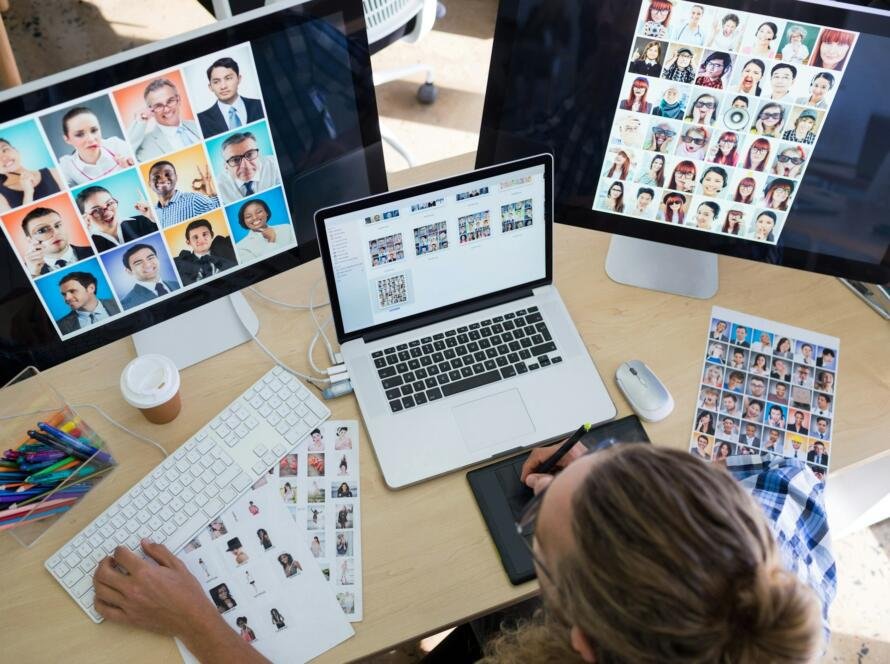 Male executive working over laptop and graphic tablet at his desk