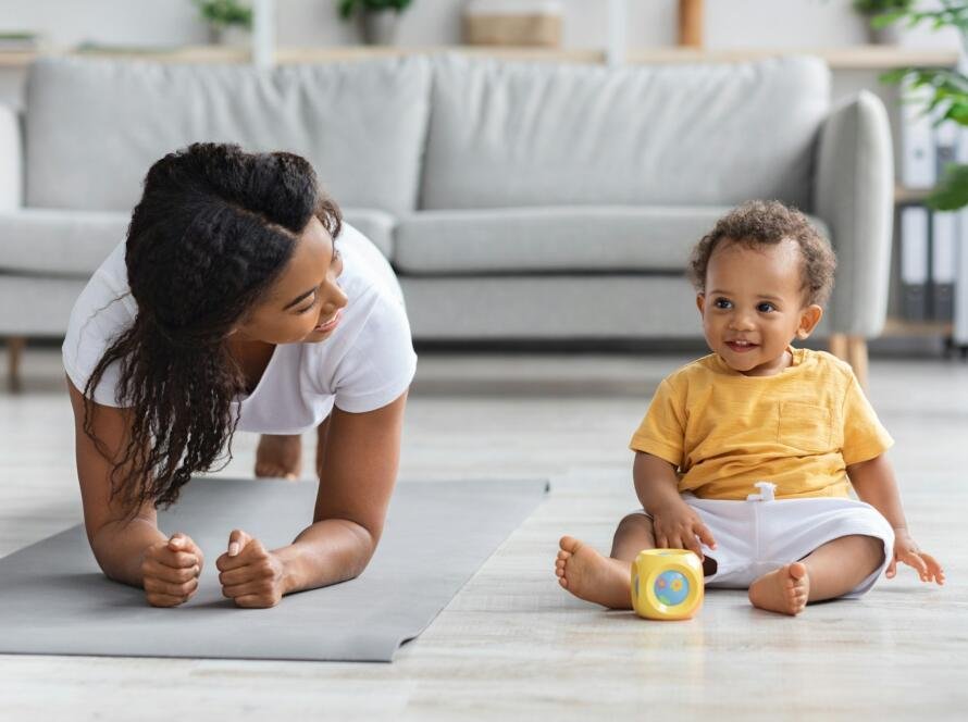 Sport At Home. Young Black Mom Making Plank Exercise With Little Baby