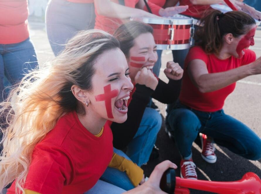 Young women cheering and shouting together in support of their local team