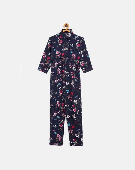 Navy blue floral jumpsuit on a wooden hanger.