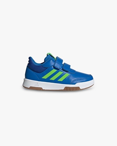 Blue sneaker with green stripes and velcro straps on a white background.