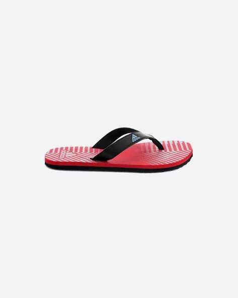 Red and black flip-flop with striped sole design.