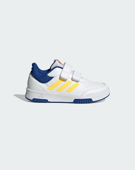 White and blue children's trainer with yellow stripes and Velcro strap.