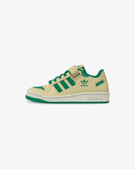 Green and beige Adidas sneaker with a strap and branding on the side.